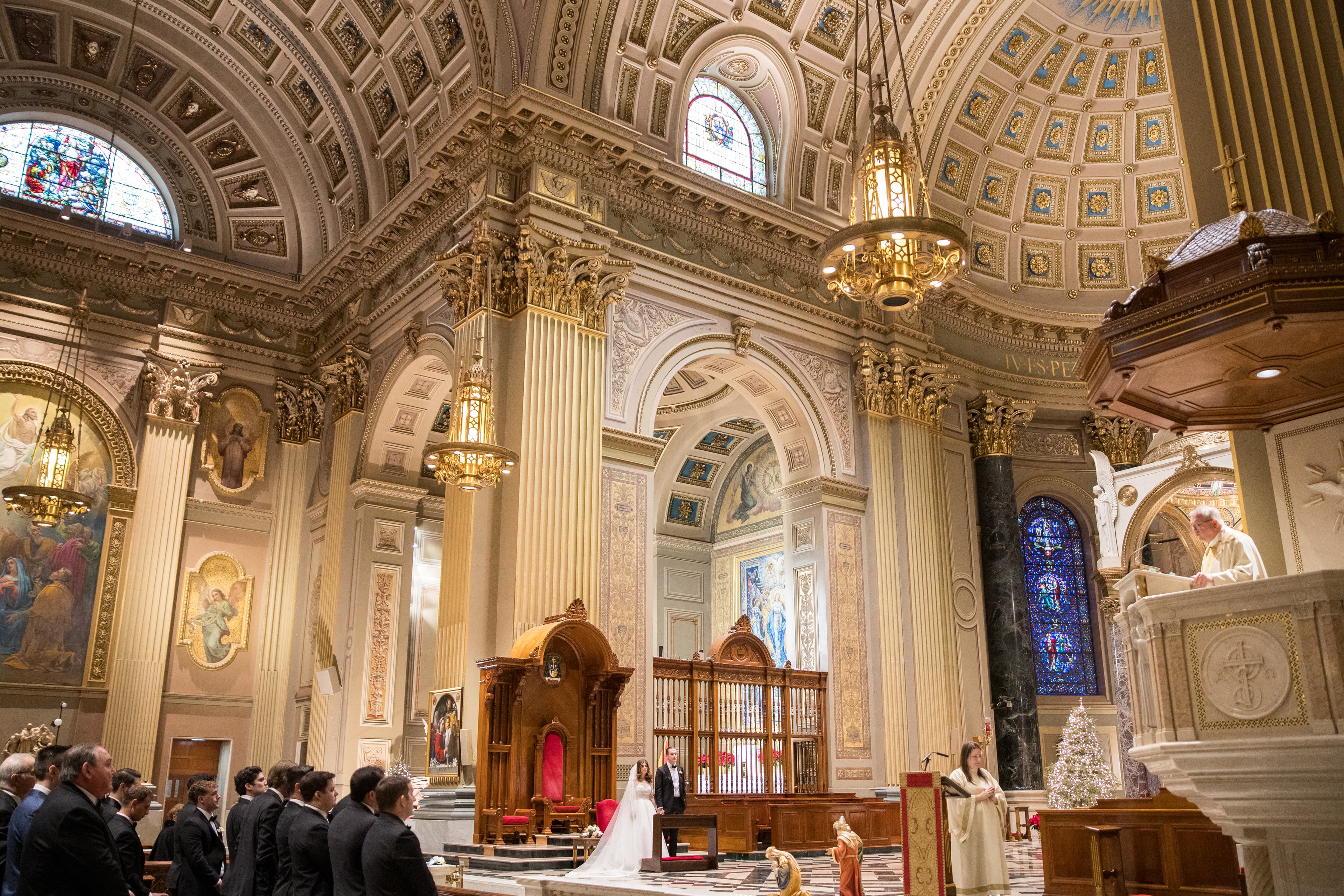 Wedding ceremony inside the Cathedral Basilica with stained glass and gilded dome