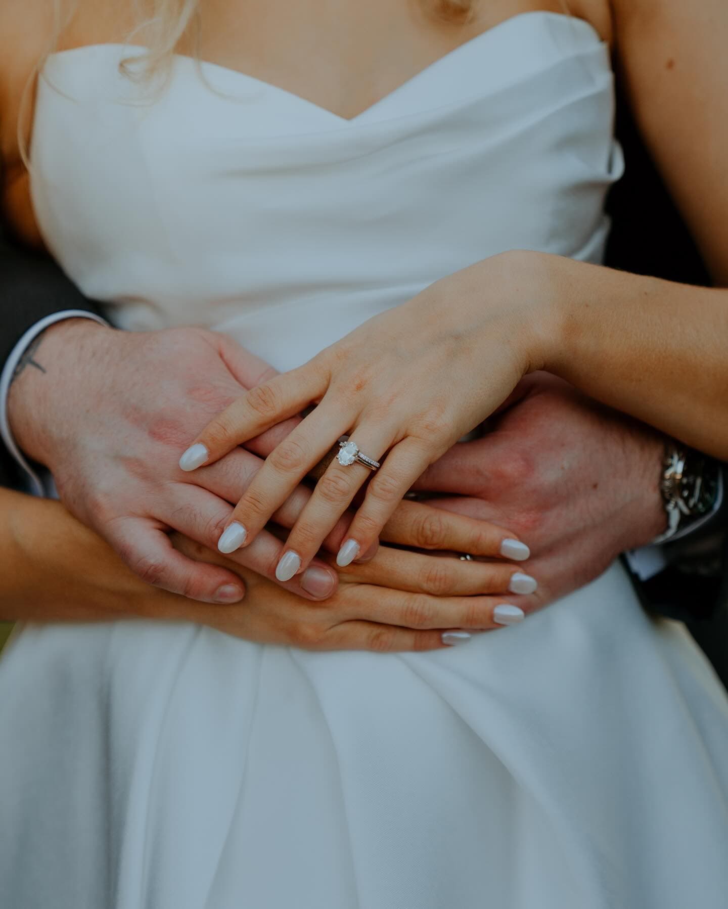 Bride and groom hands with engagement ring detail